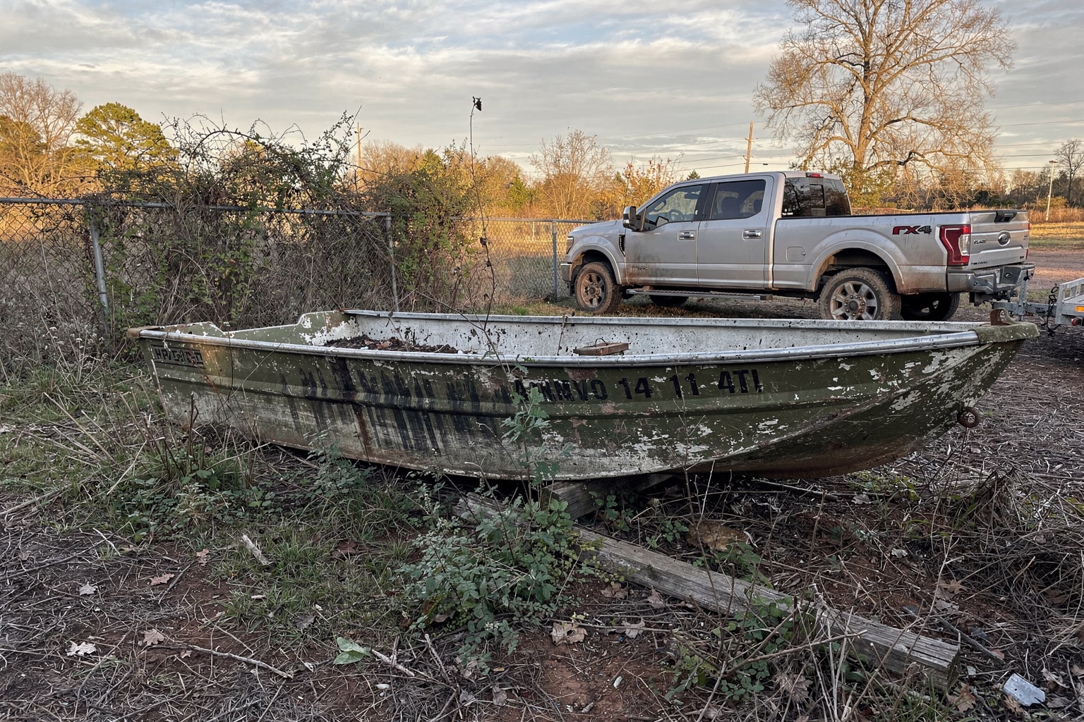 Junk boat disposal Alabama: abandoned aluminum jon boat removal from overgrown rural property