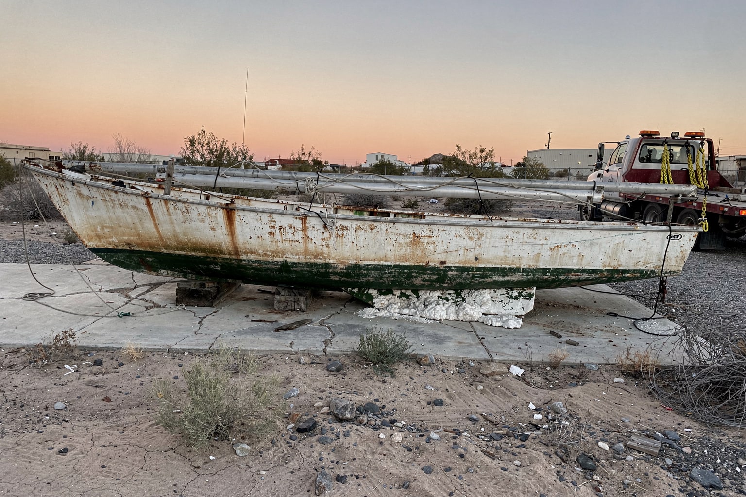 Abandoned sailboat disposal in Las Vegas lot with corroded hull before Hansons removal service