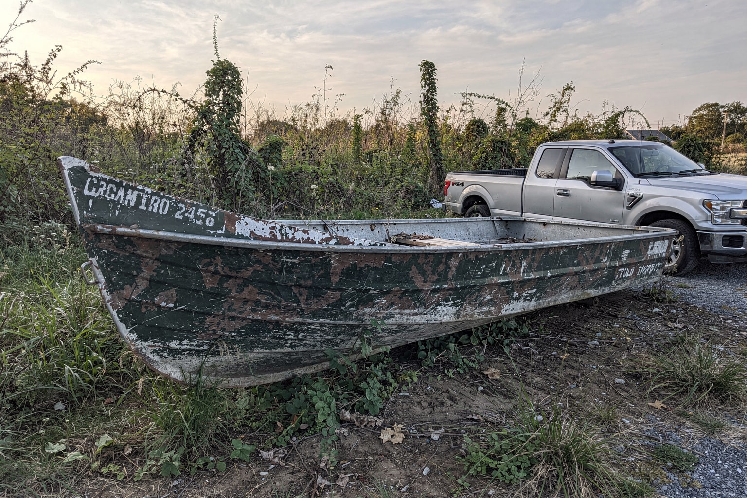 Abandoned 16-foot aluminum jon boat removal from overgrown Rhode Island boatyard salvage site