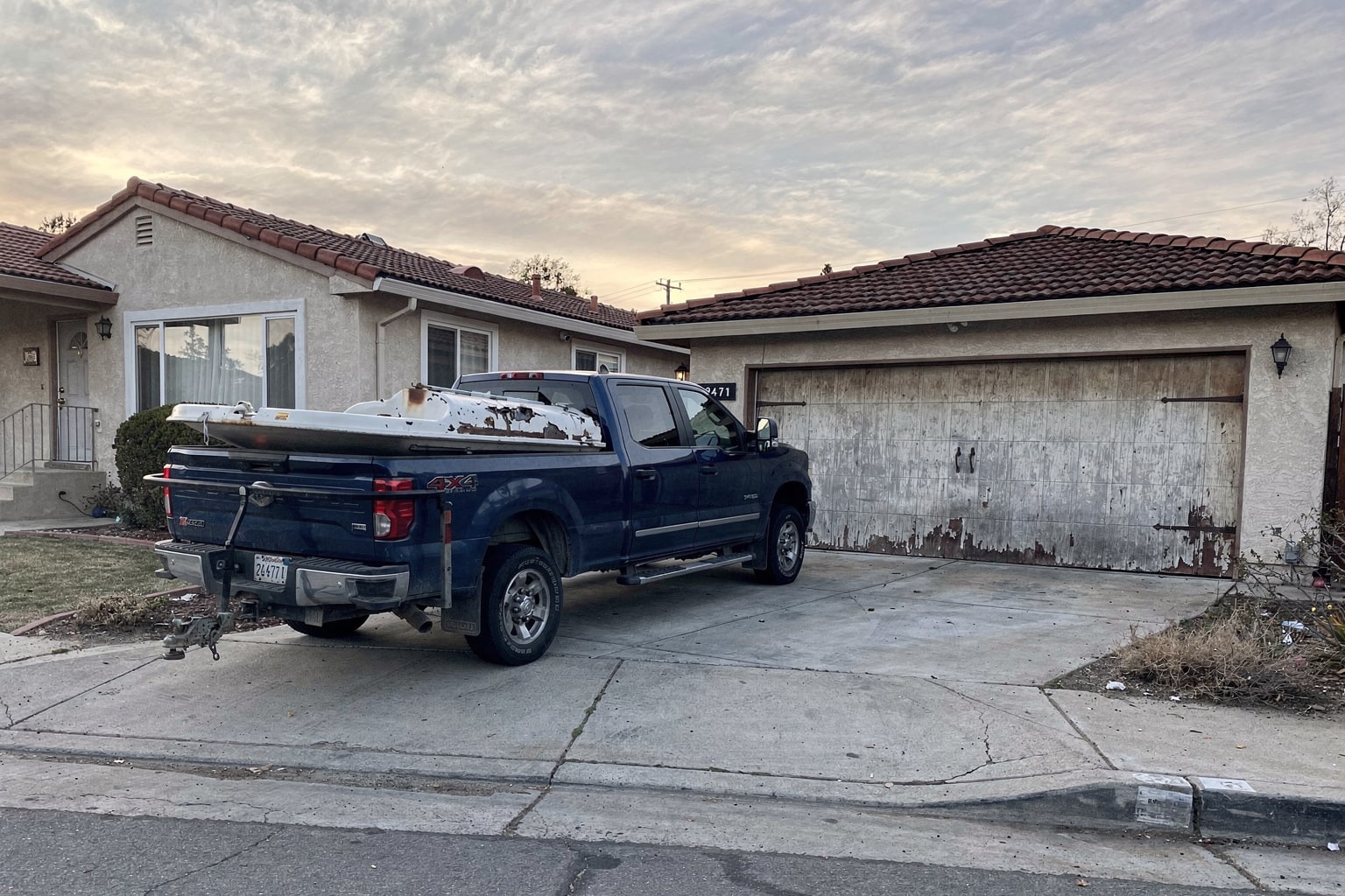 Junk boat removal and disposal San Jose with damaged cabin cruiser powerboat on trailer ready for hauling away