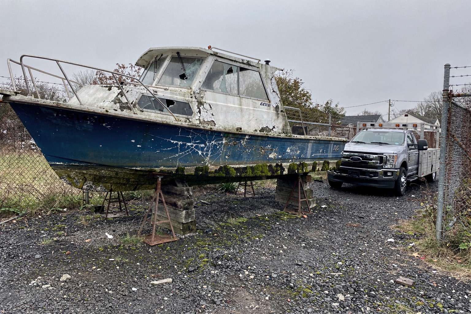 Boat disposal Staten Island NY abandoned property showing junk boat removal from neglected storage lot