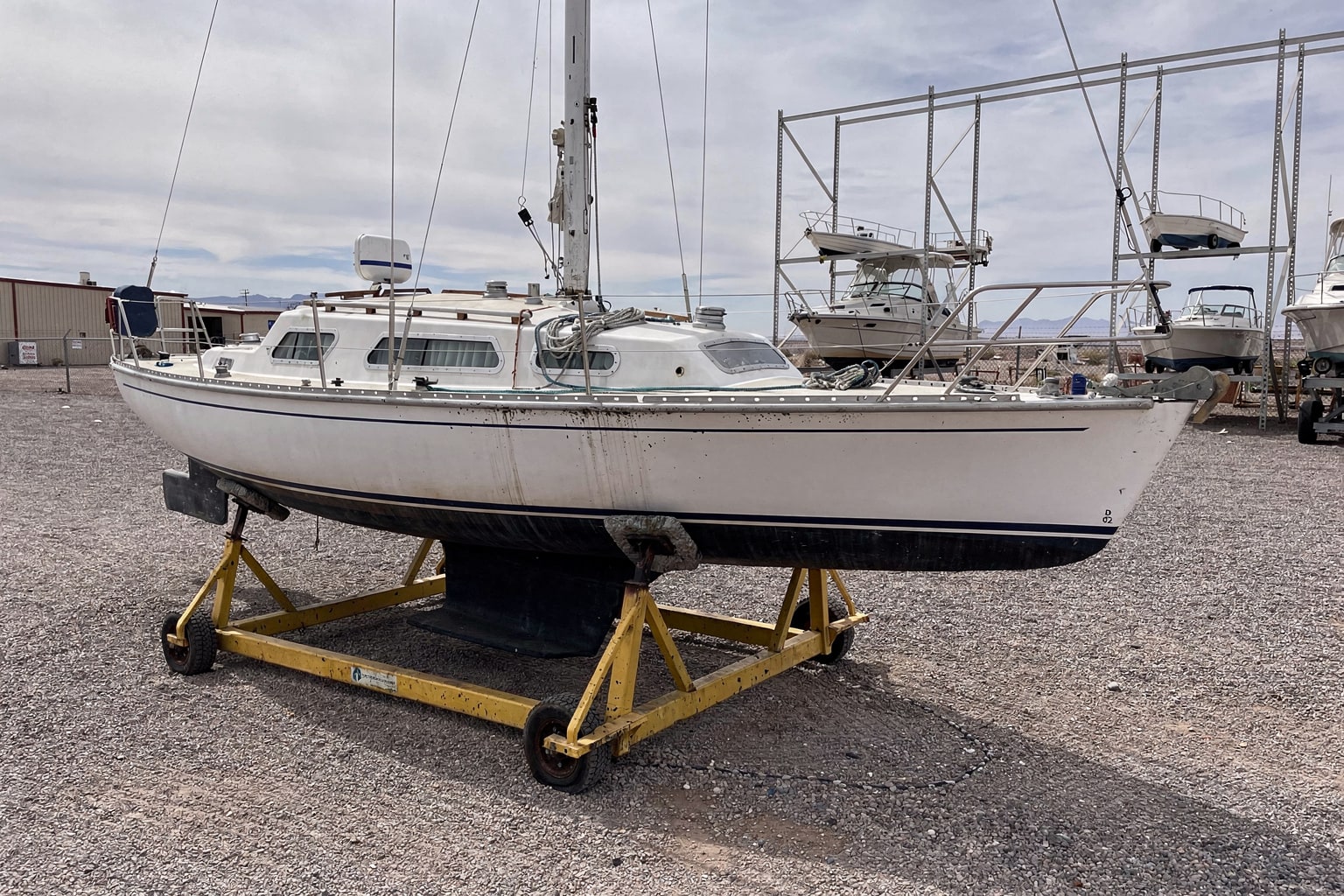28-foot sailboat on steel cradle junk boat removal marine salvage Arizona boatyard