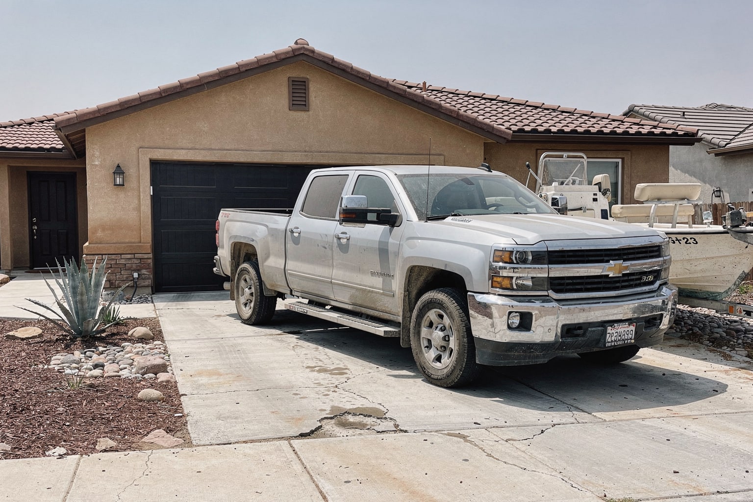 Boat removal service in Bakersfield CA with junk boat loaded on trailer behind pickup truck