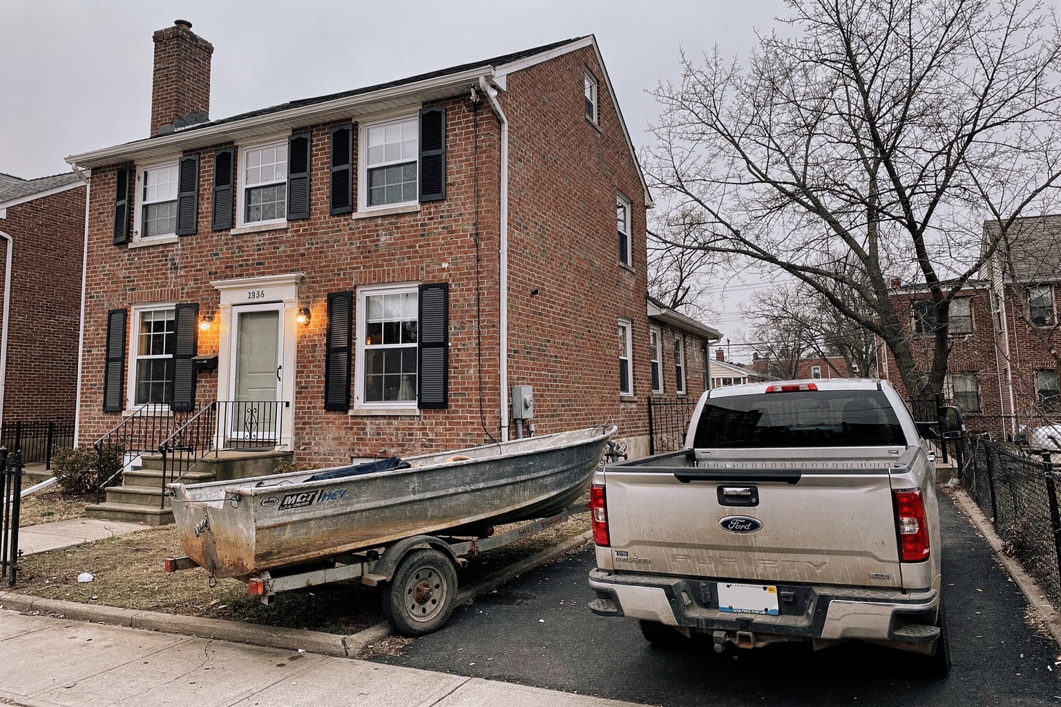 Silver pickup truck with aluminum fishing boat on trailer in Brooklyn driveway ready for junk boat removal