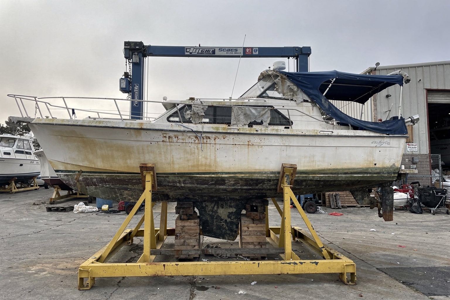 Large fiberglass cruiser on cradle at California boatyard, professional boat removal and disposal services