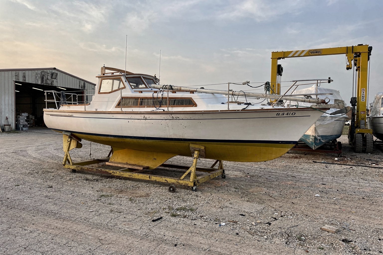 Junk sailboat removal Dallas boatyard on steel cradle with travel-lift equipment commercial disposal