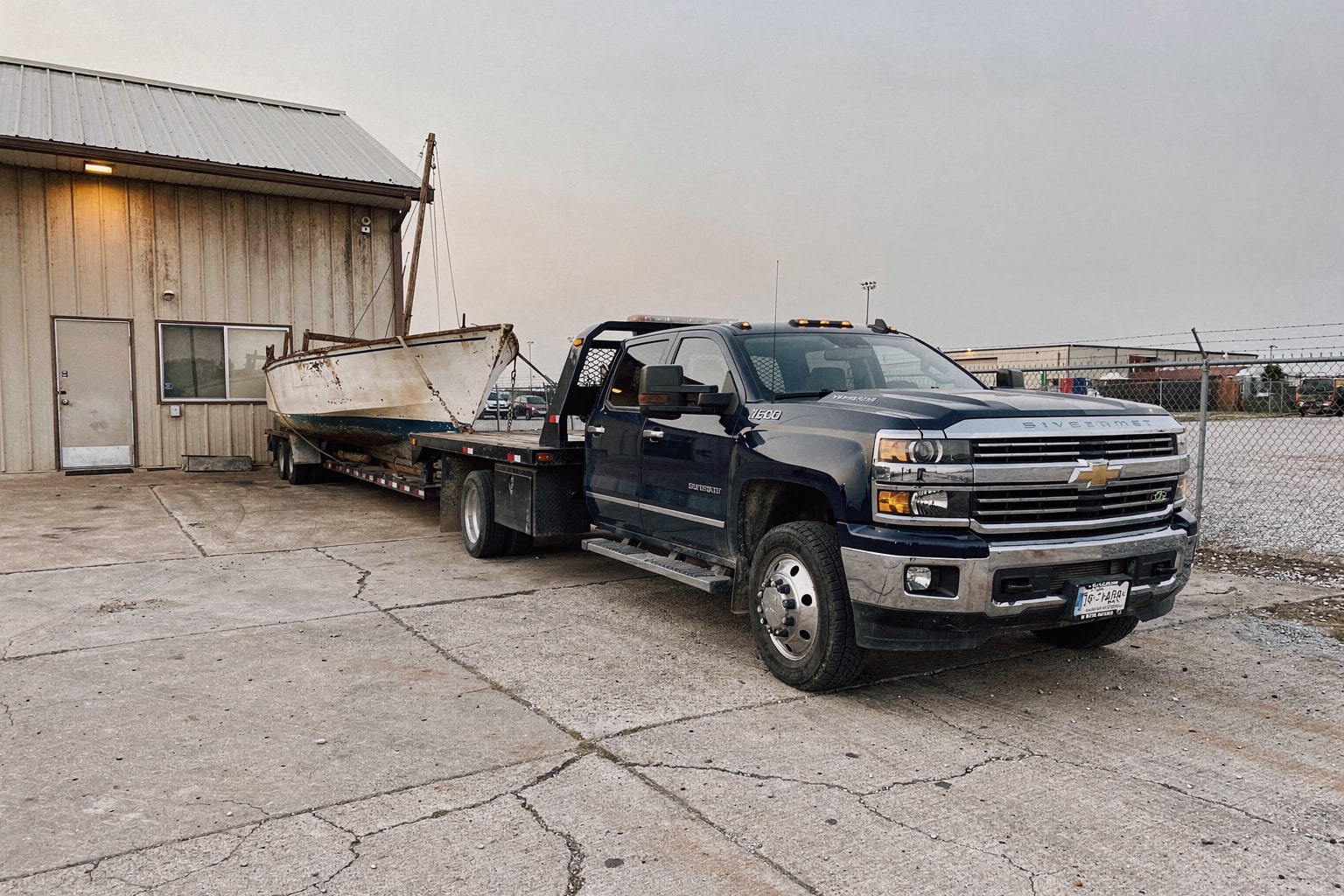 Boat removal and disposal service in Arlington Texas, large sailboat on flatbed truck for junk removal