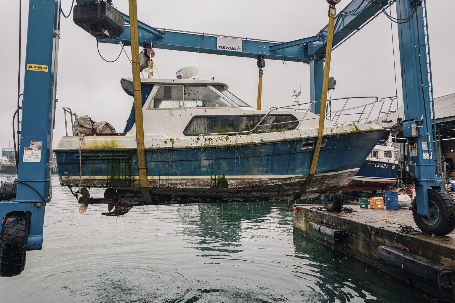 Boat disposal Maryland: commercial marine salvage operation using travel-lift to remove cabin cruiser from water
