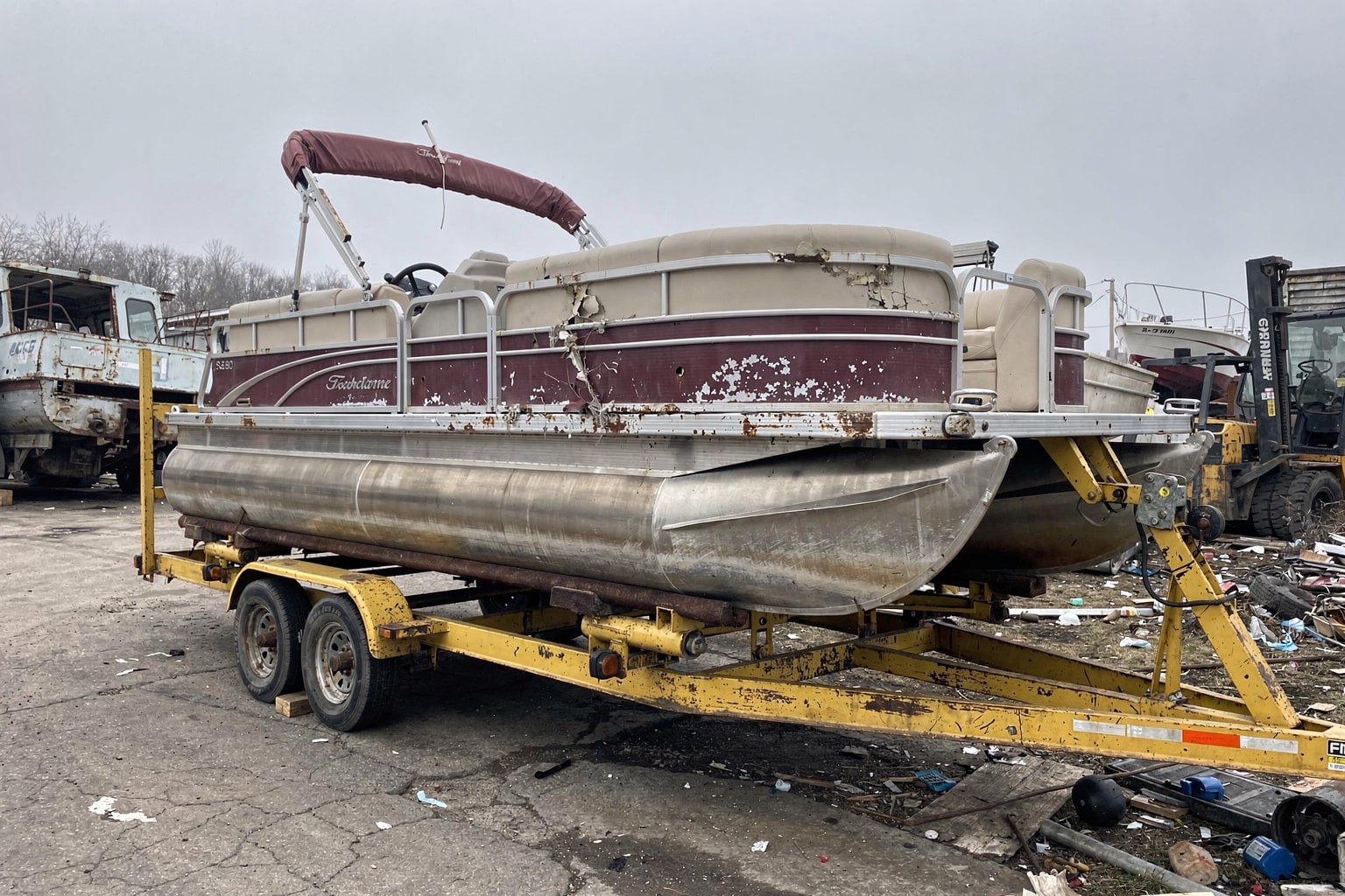 Marine salvage yard boat removal, pontoon boat on hydraulic trailer, commercial Minnesota facility