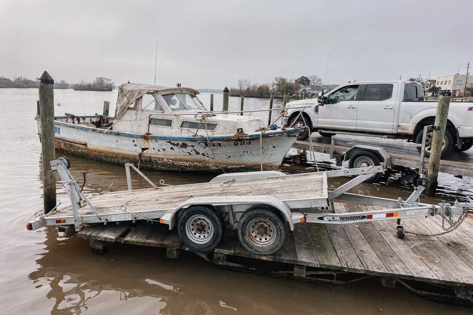 Junk boat removal New Orleans marina dock with pickup truck ready for boat disposal
