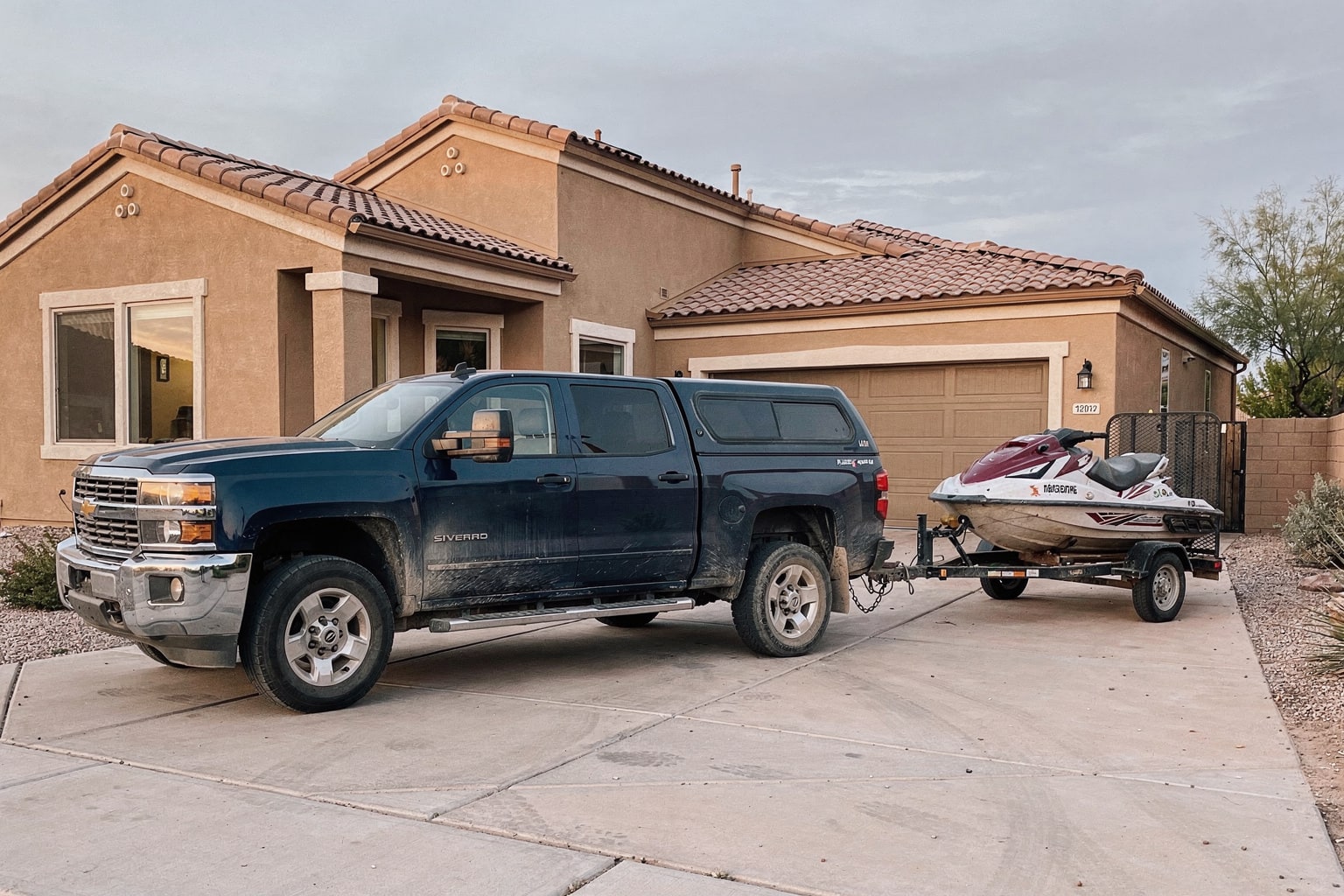 Weathered jet ski junk removal on utility trailer in Phoenix residential driveway