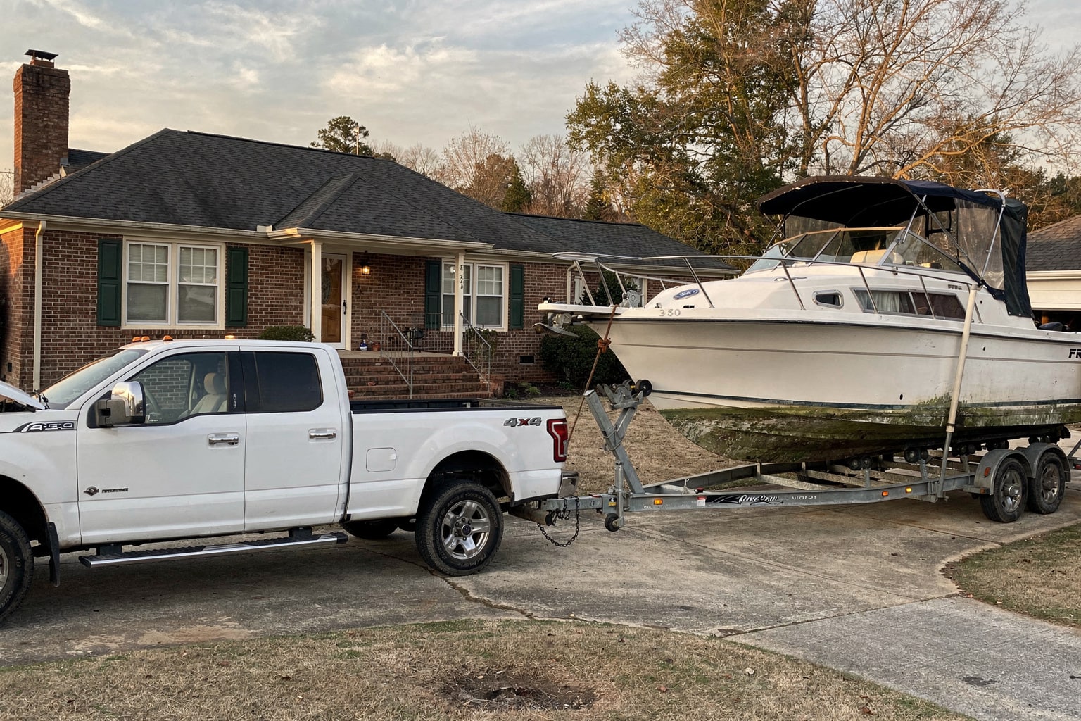 Boat removal in progress Raleigh NC with winch pulling cabin cruiser onto trailer