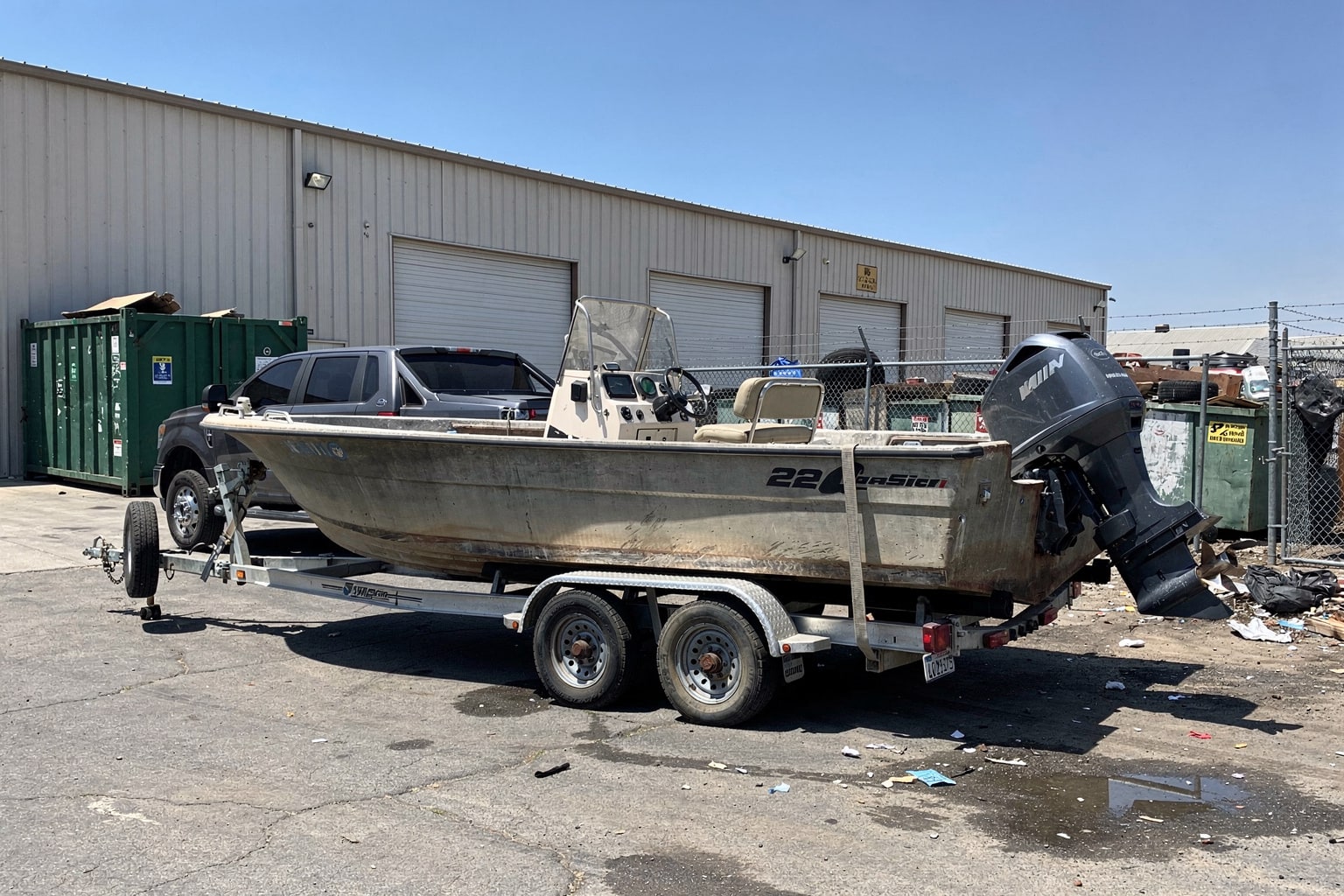 Boat removal Sacramento — damaged center console on trailer at commercial warehouse loading dock