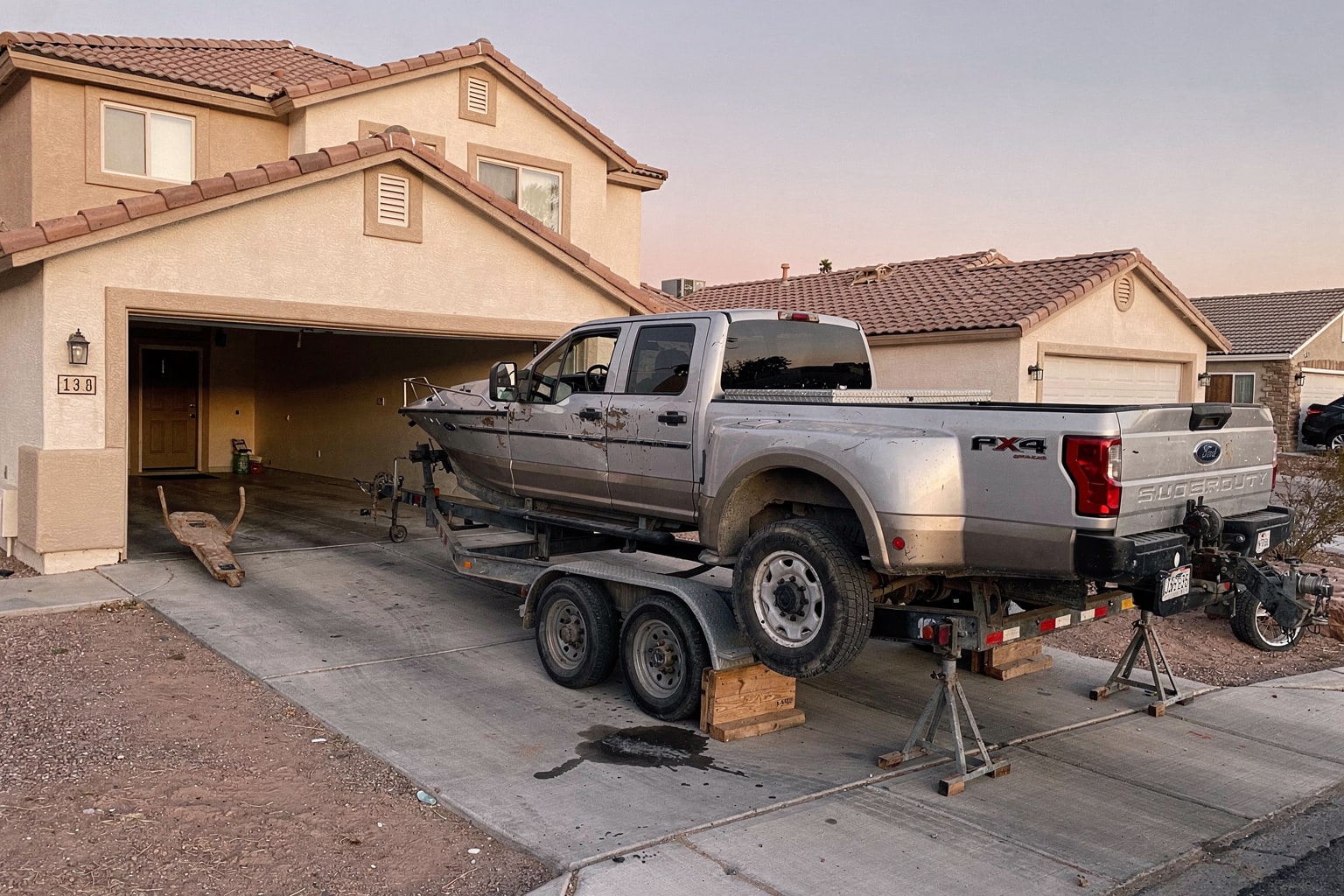 Boat removal service in Las Vegas — damaged fiberglass day cruiser being actively winched onto pickup truck trailer