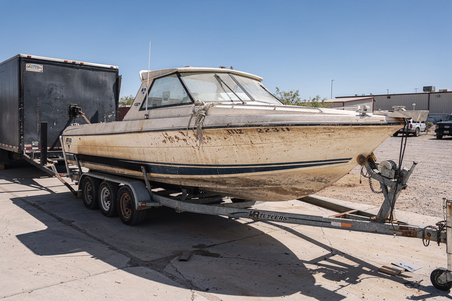 Commercial boat disposal service in Tucson, removal truck securing junk boat for hauling