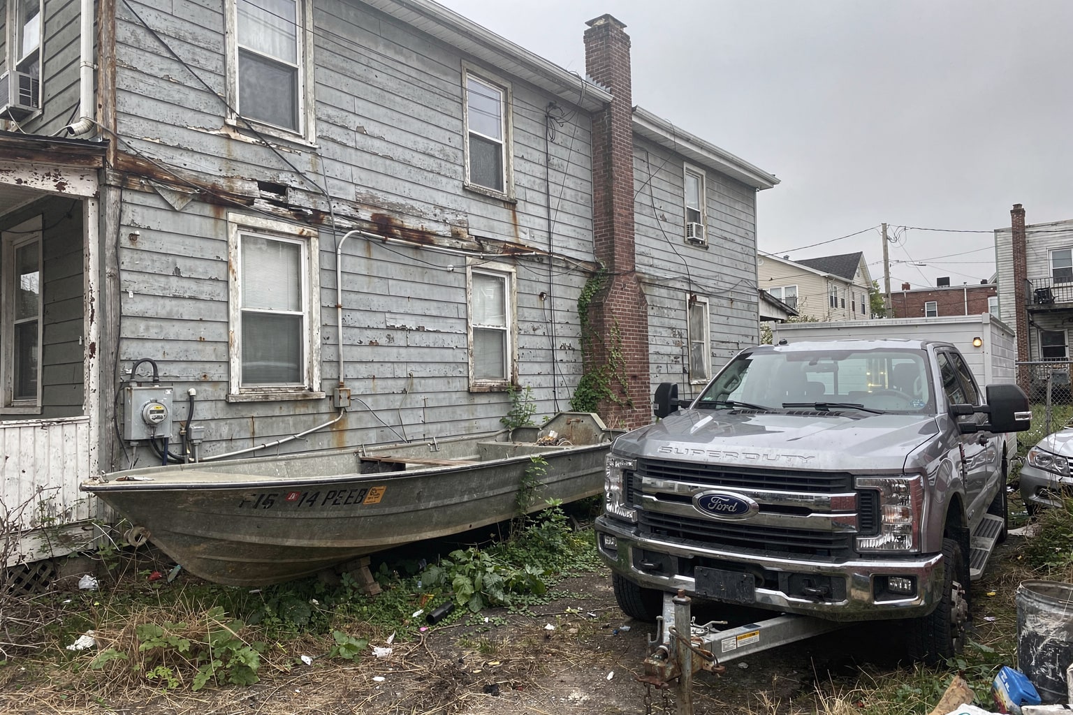 Junk boat removal Bronx abandoned boat disposal from overgrown residential lot