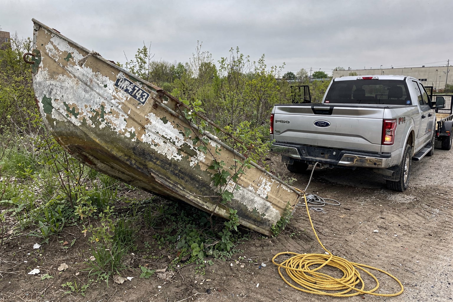 Abandoned junk boat removal Chicago vacant lot, weathered aluminum vessel disposal